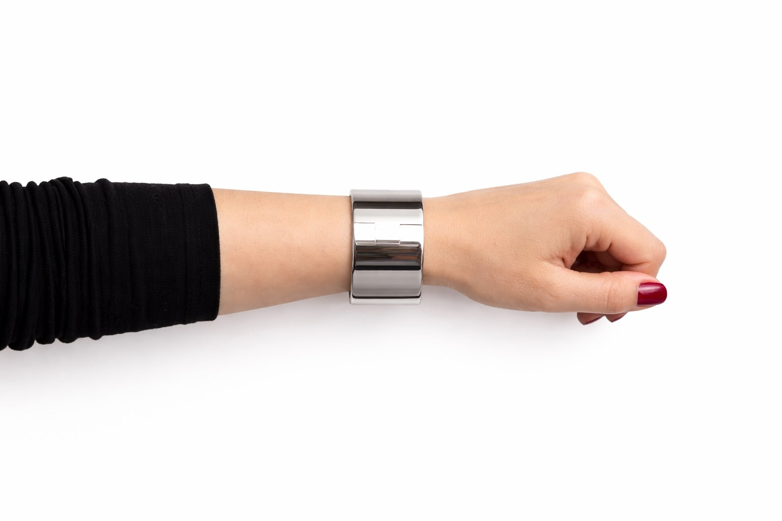 Wide polished steel deSade wrist band worn on a model's wrist, side view