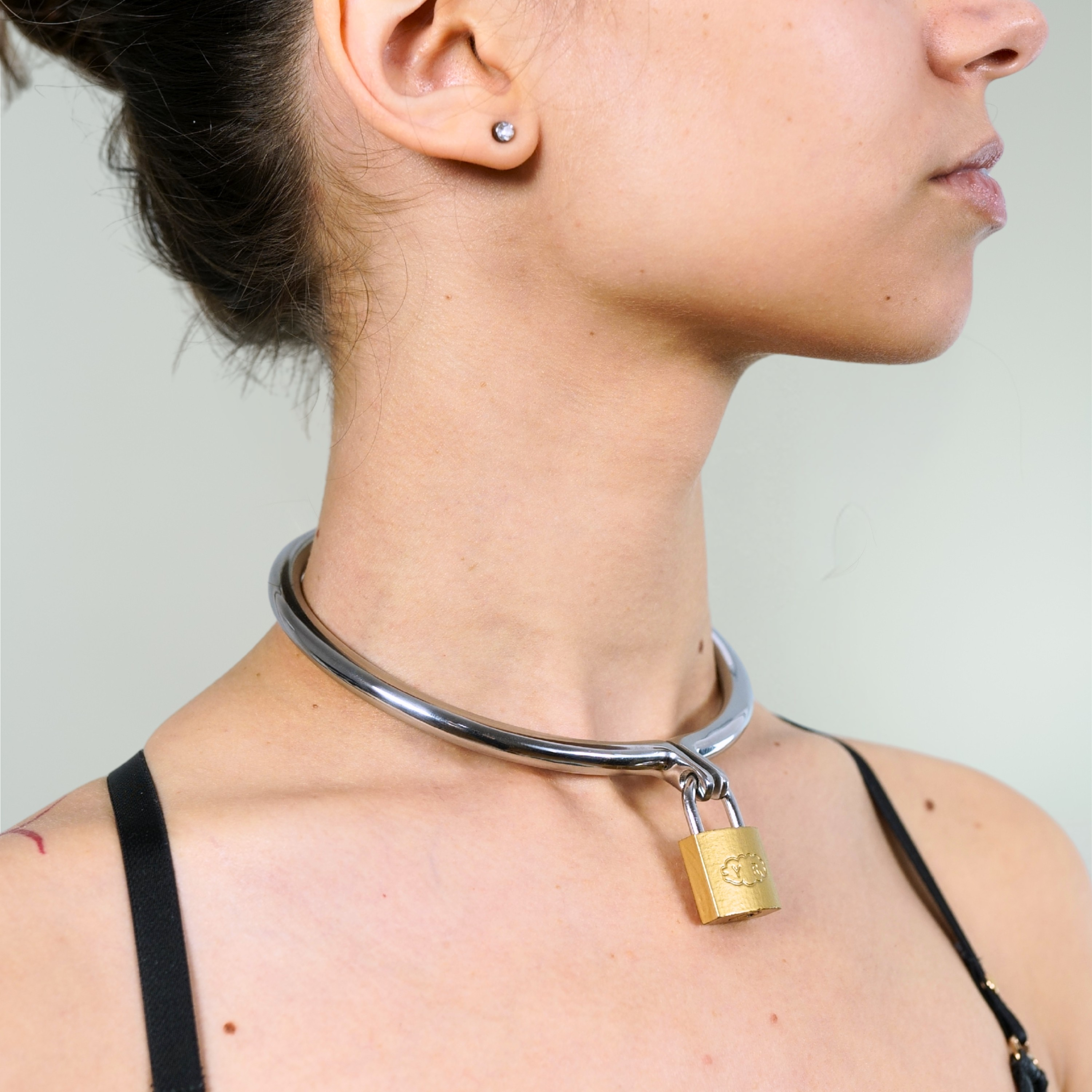 Steel day collar with padlock worn on a model's neck