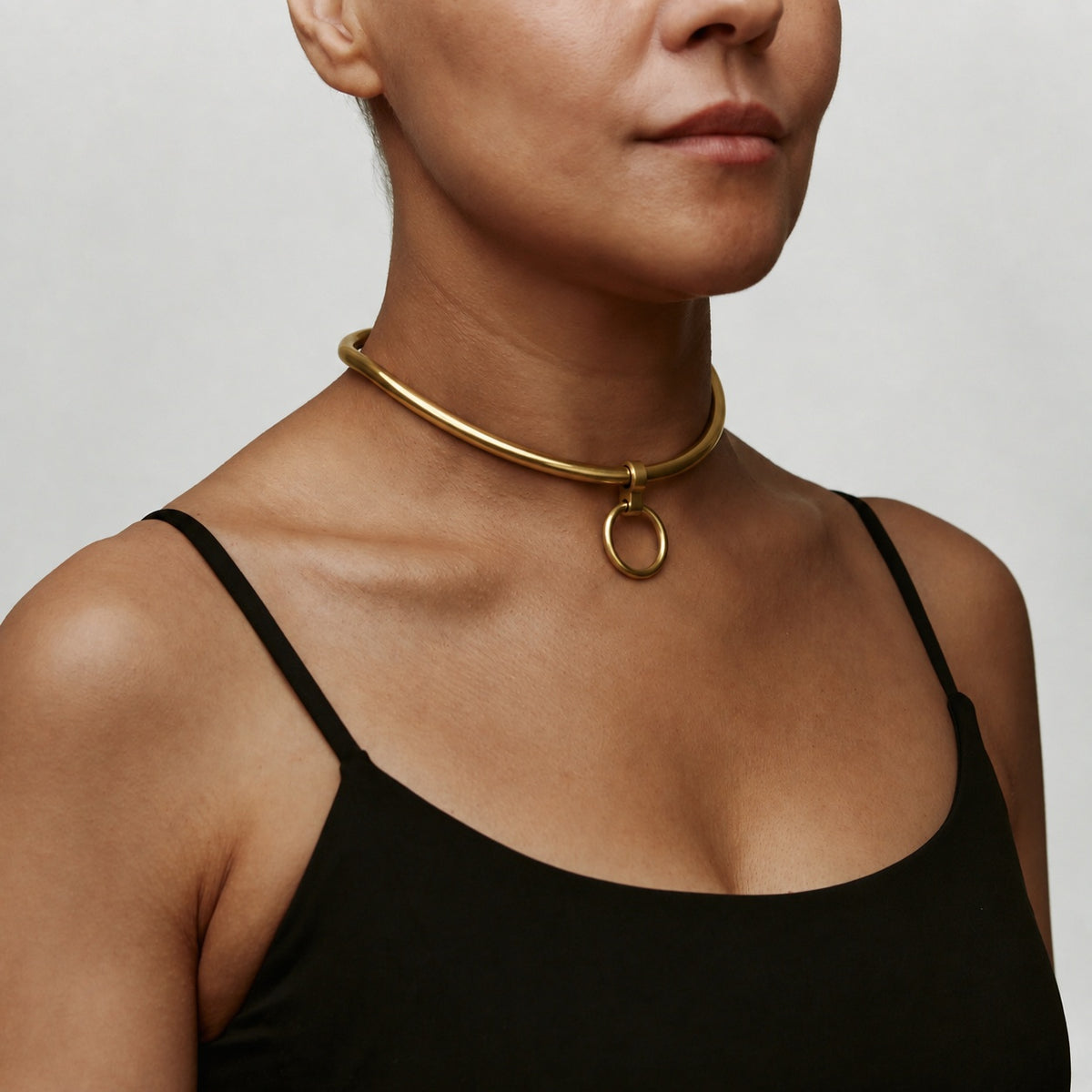 deSade gold day collar with front O-ring worn on the neck, angled view