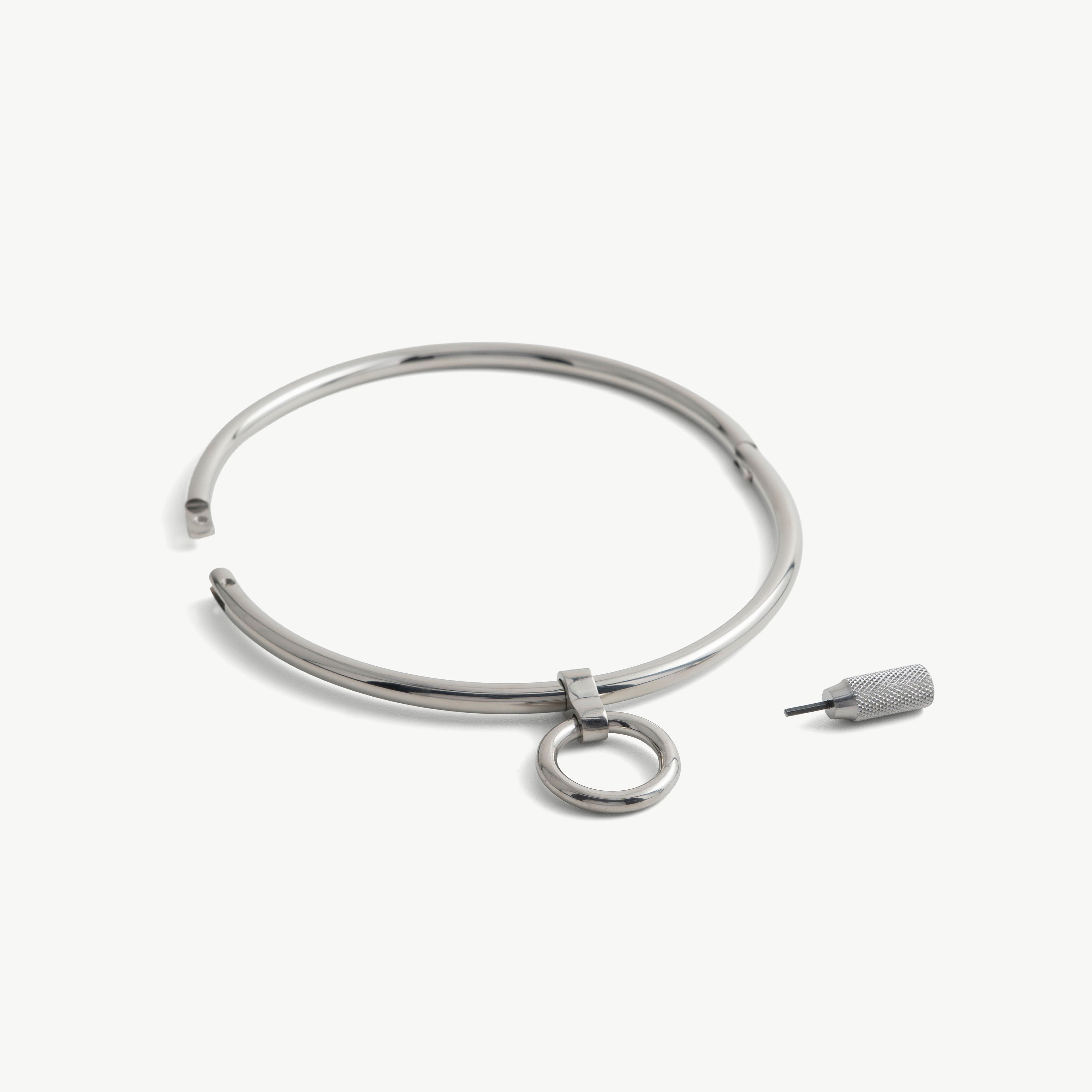 deSade silver round day collar shown open beside its hex key