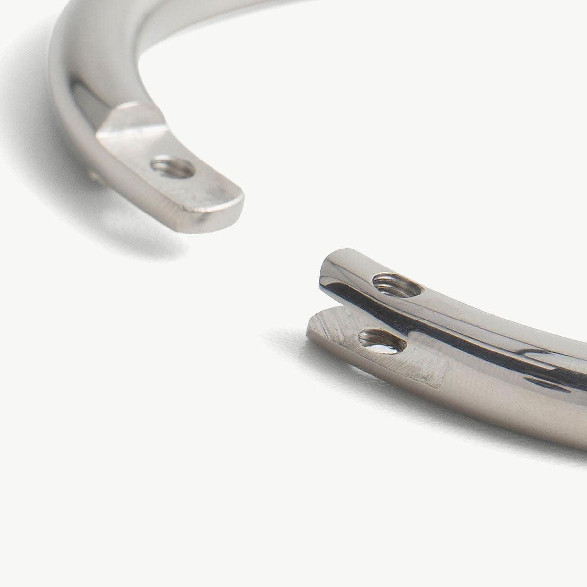 Extreme close-up of the deSade silver wrist bracelet's open ends and lock screw hole