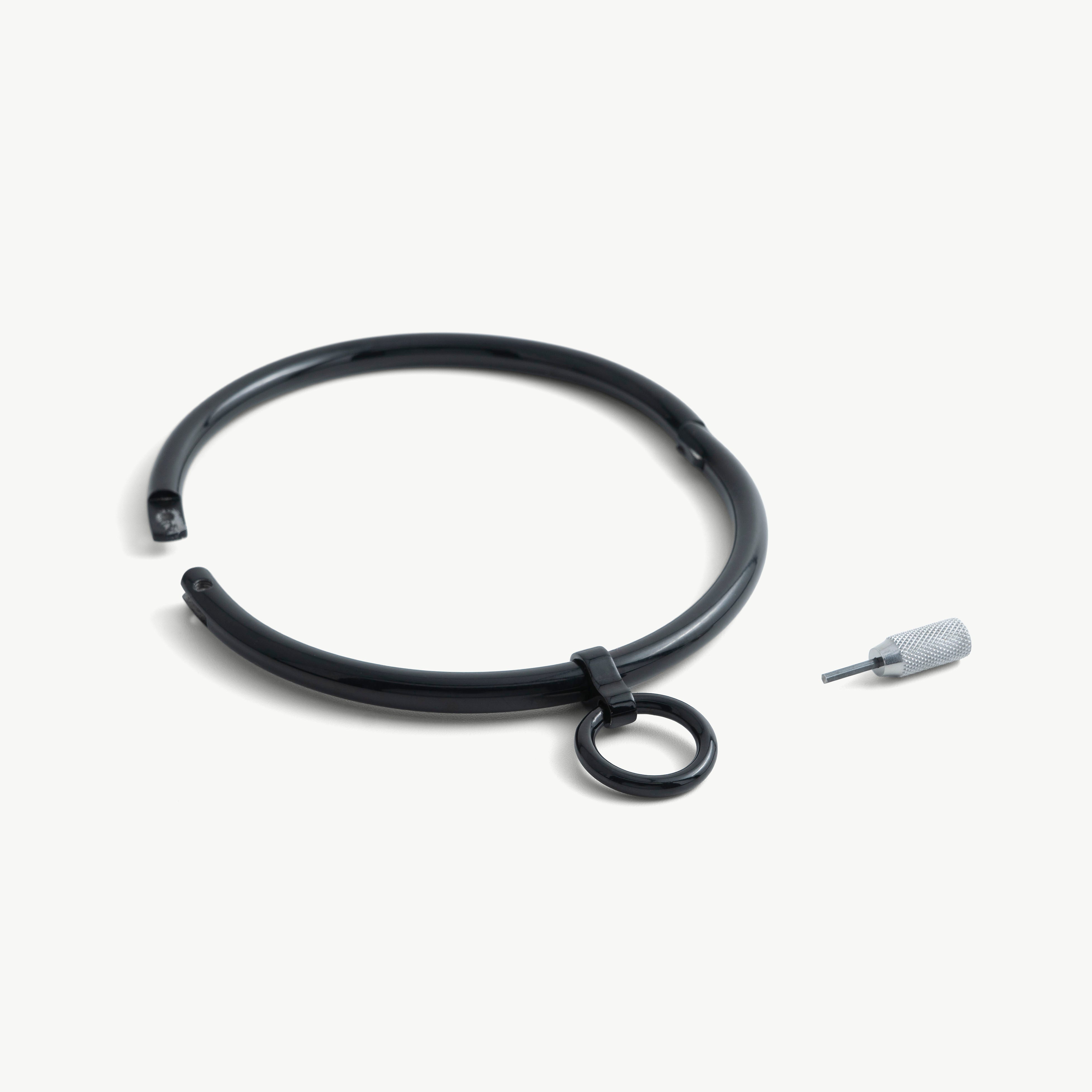 deSade black round day collar shown open beside its hex key