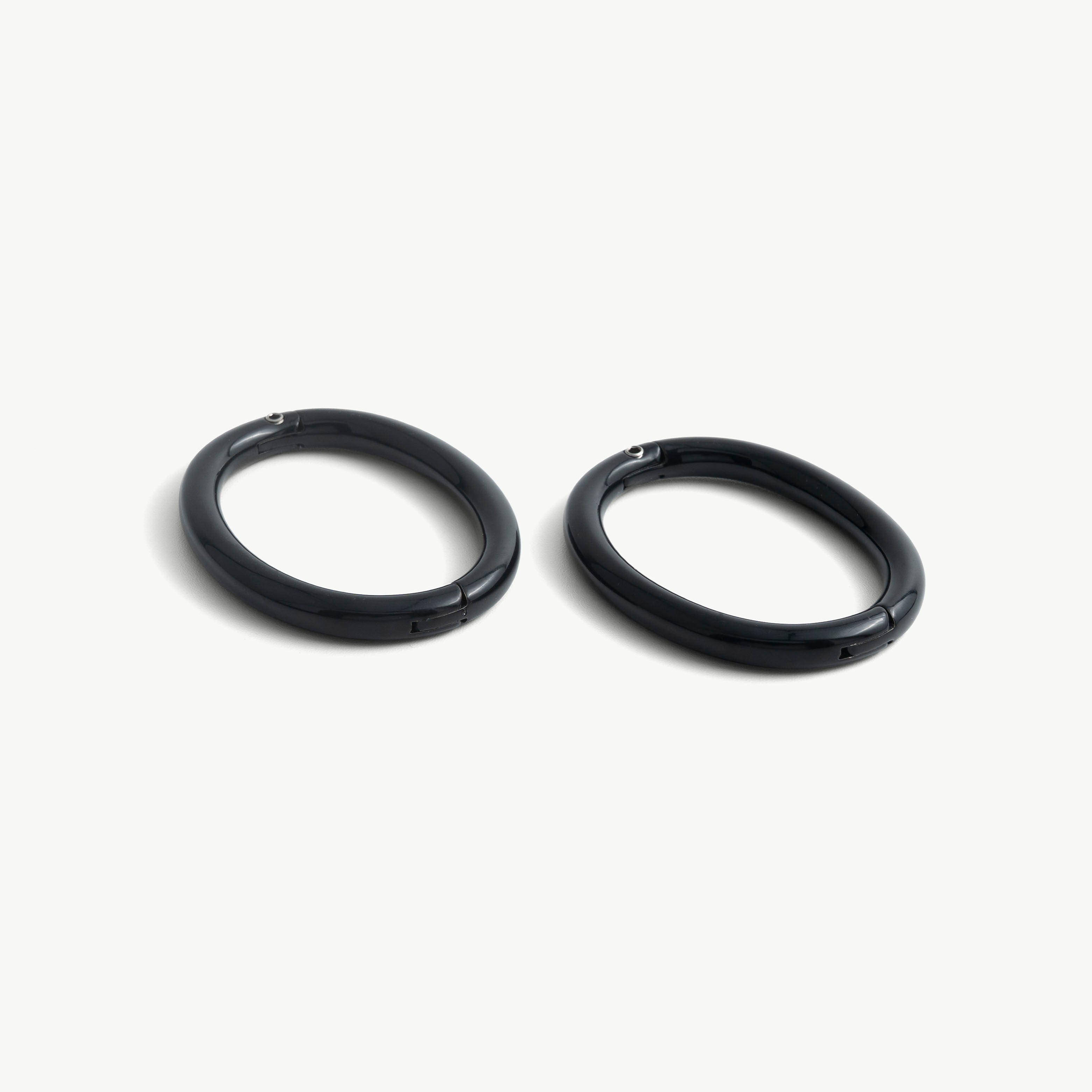 Pair of deSade black oval wrist bracelets shown together in 8mm steel
