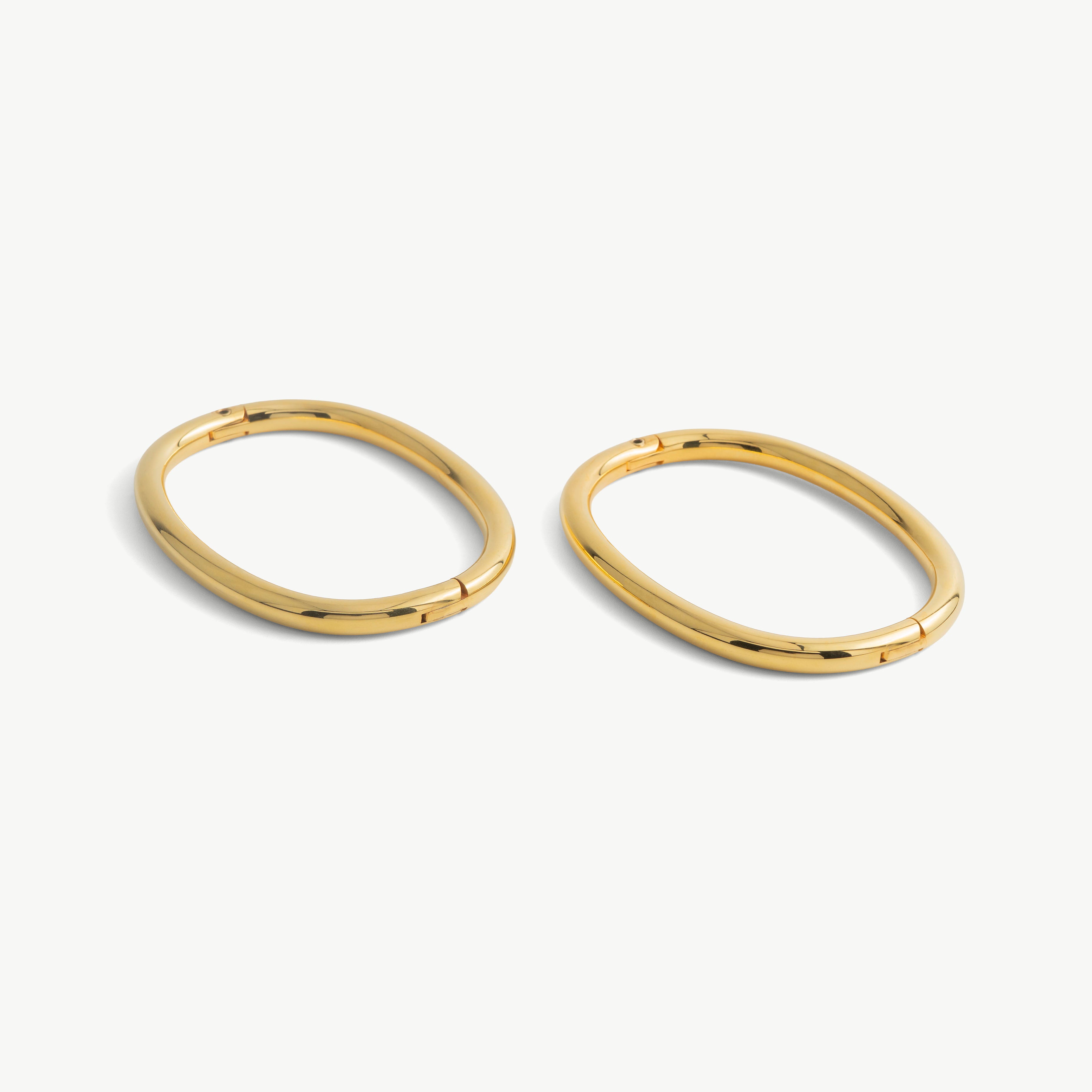 Pair of deSade gold oval ankle bracelets shown together in 8mm steel