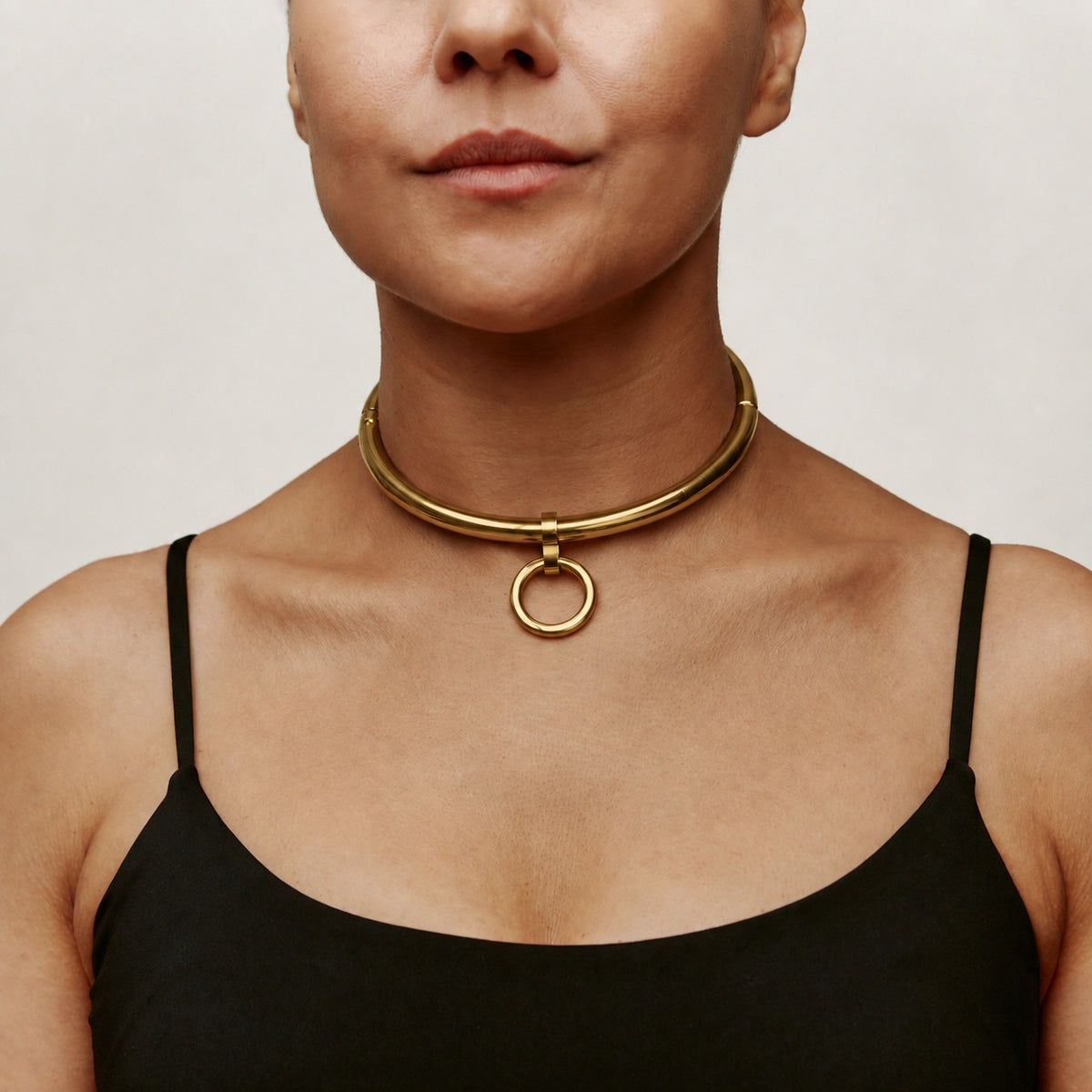 Gold deSade 8mm round day collar worn on the neck, front view with the O-ring