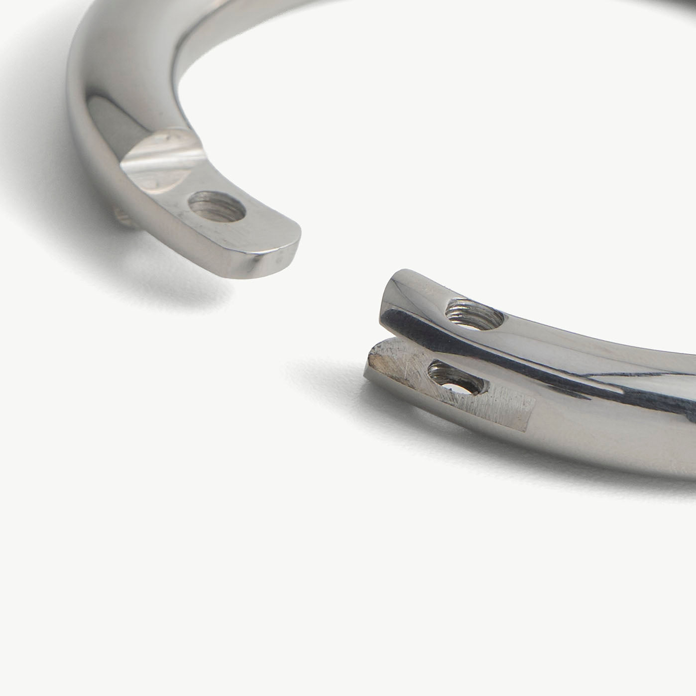 Extreme close-up of the deSade silver wrist bracelet's open ends and lock screw hole