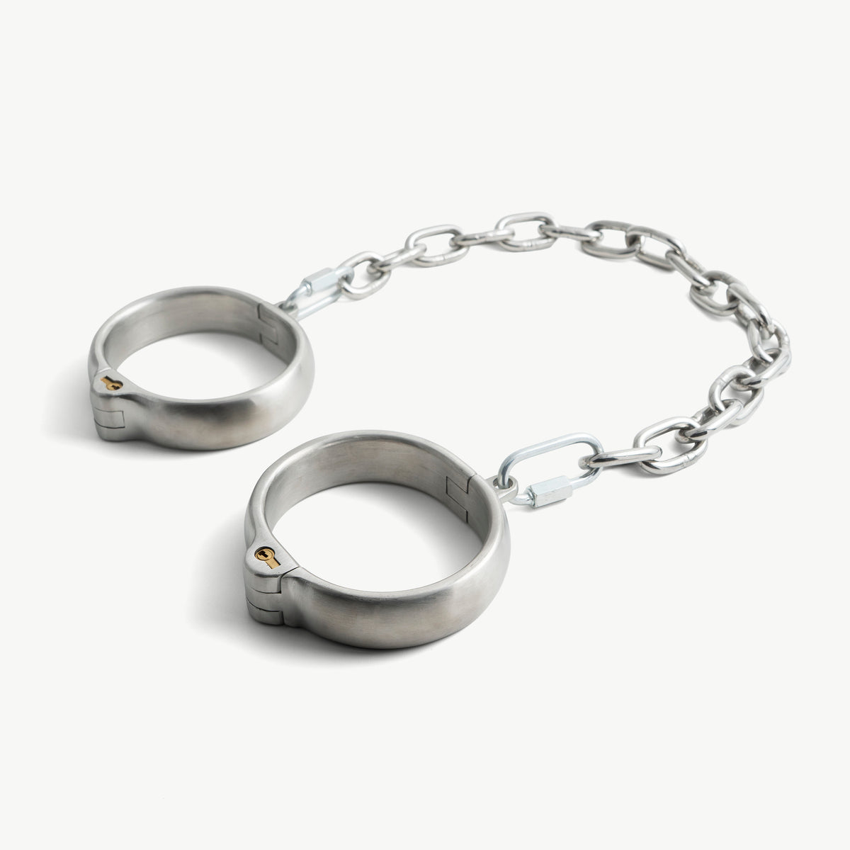 Age of Bondage rounded legcuffs in brushed stainless steel with push-in lock and chain, angled view