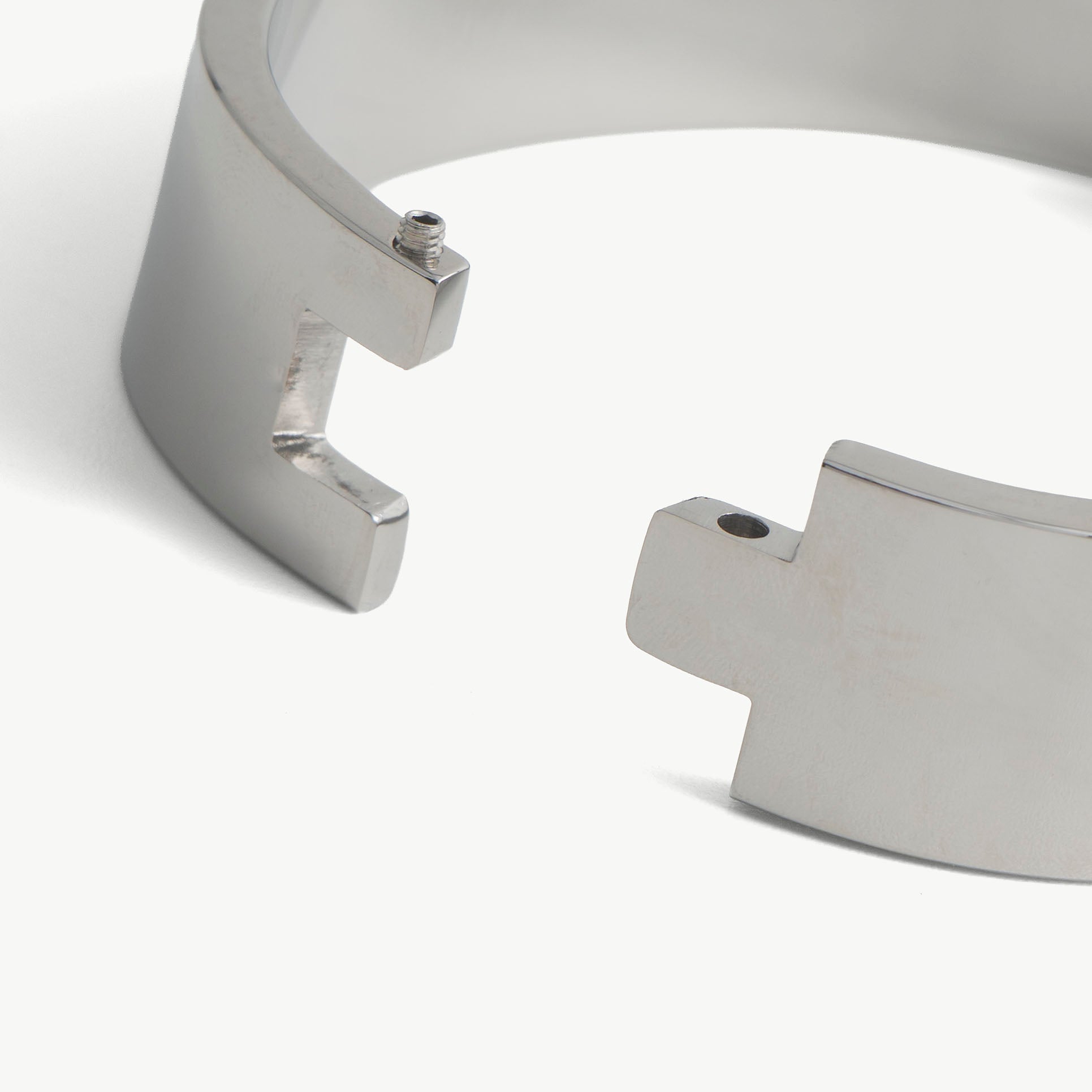 Close-up of the deSade ankle band open hinge ends with screw holes for the hex lock
