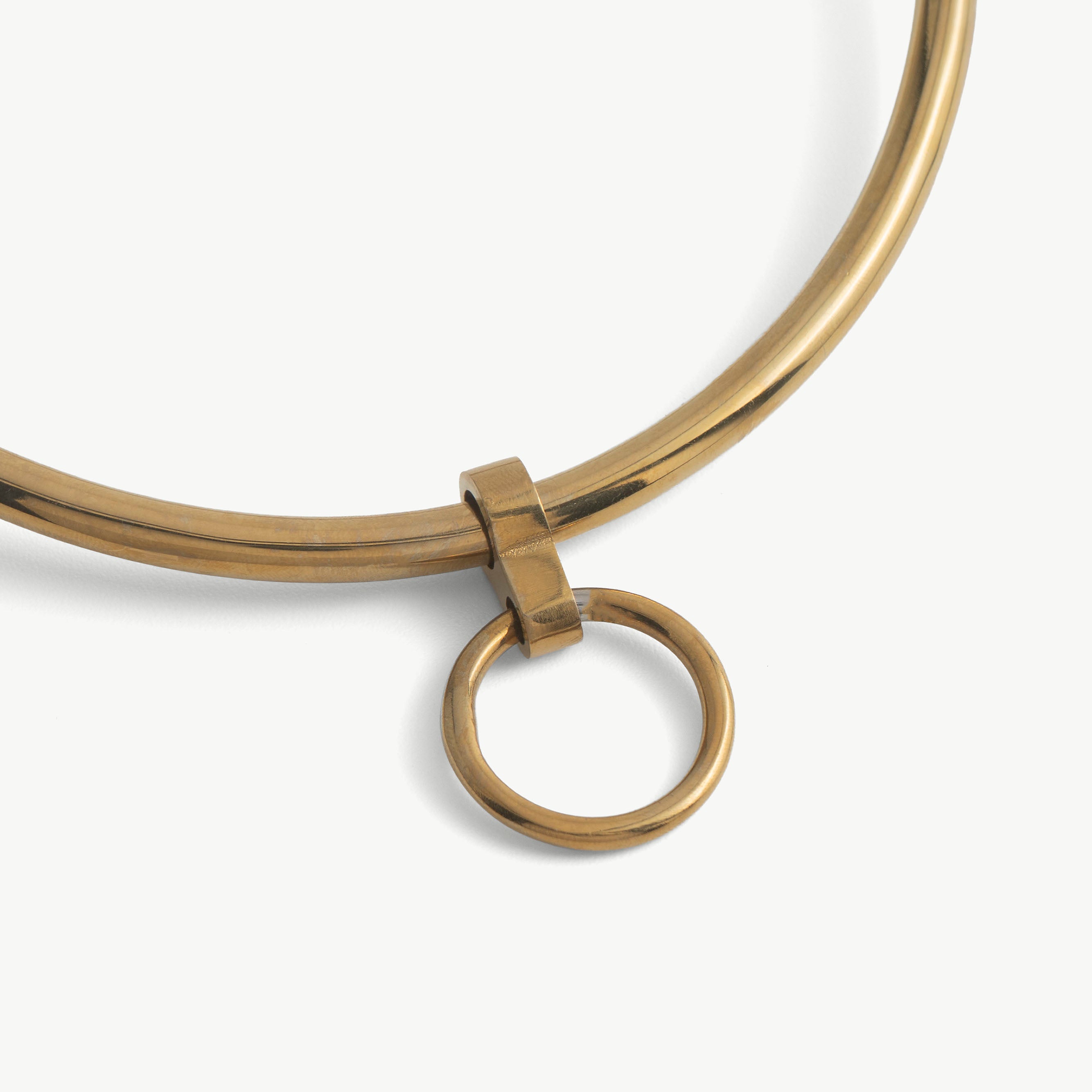 Close-up of the deSade gold day collar's front O-ring and polished band