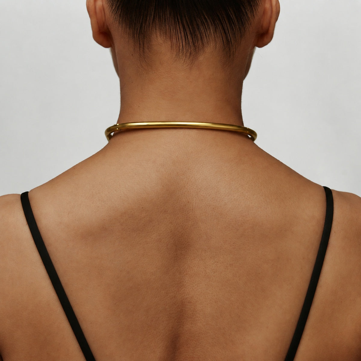 Back view of the deSade gold day collar worn on the neck
