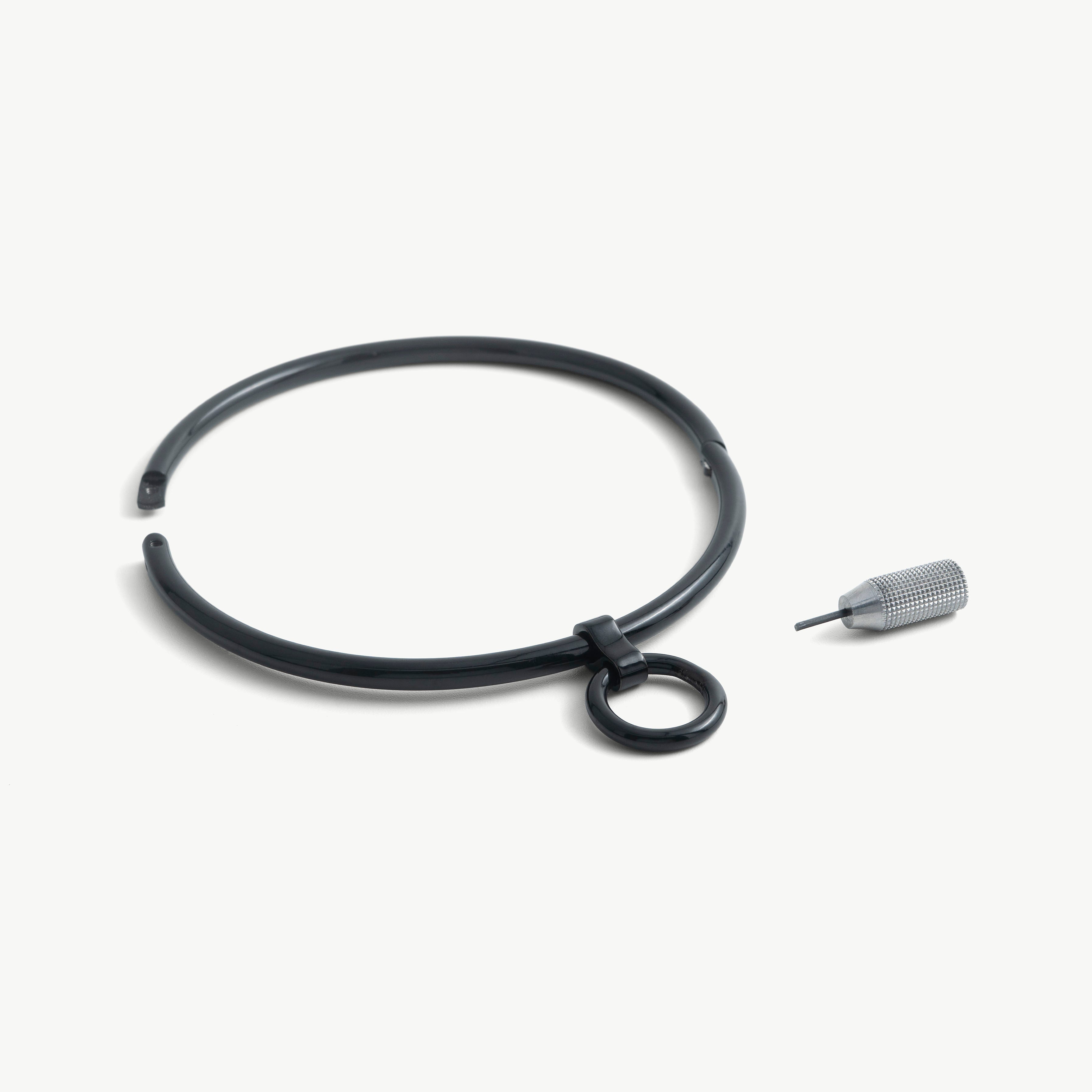 deSade black round day collar shown open beside its hex key