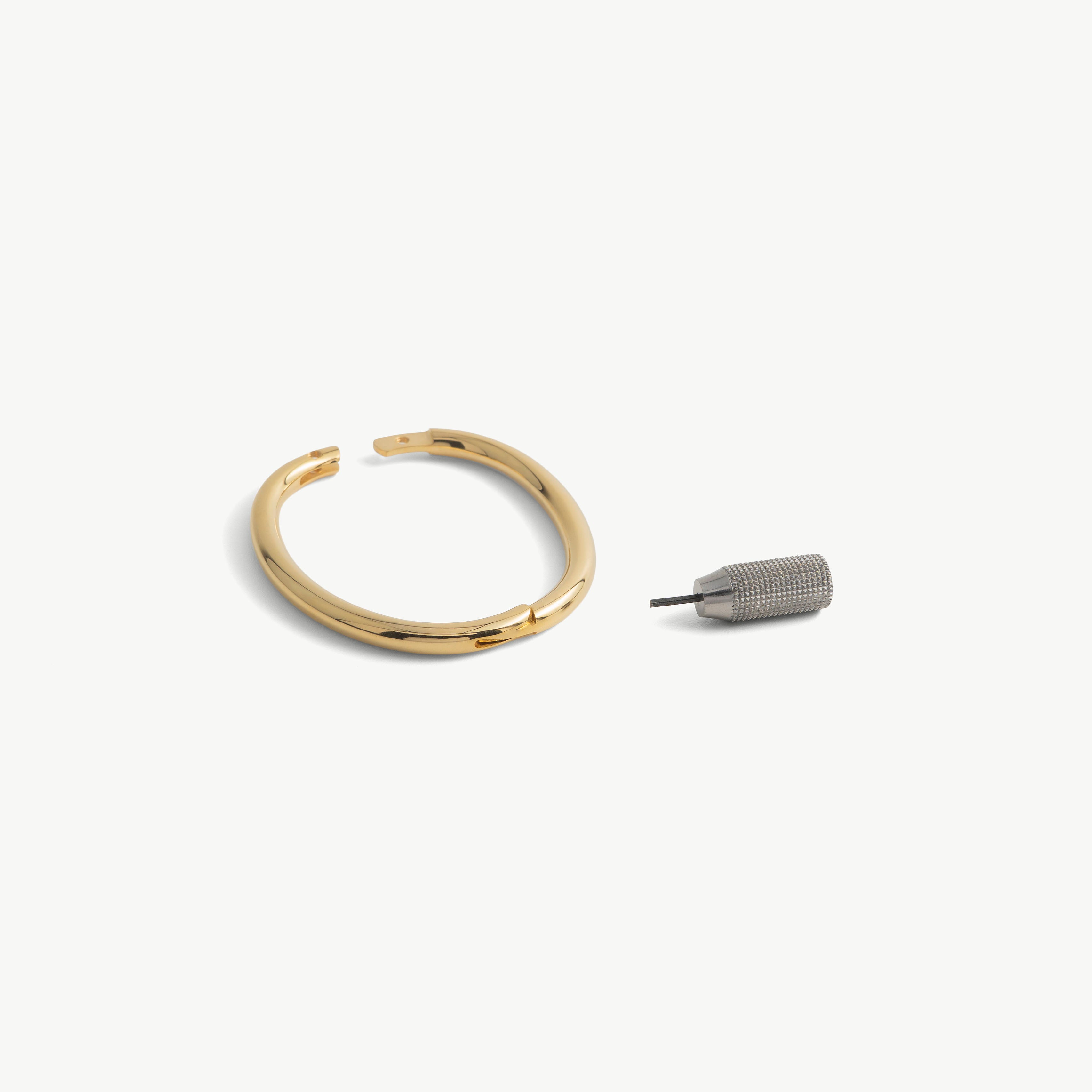 deSade gold wrist bracelet shown open beside its hex key tool