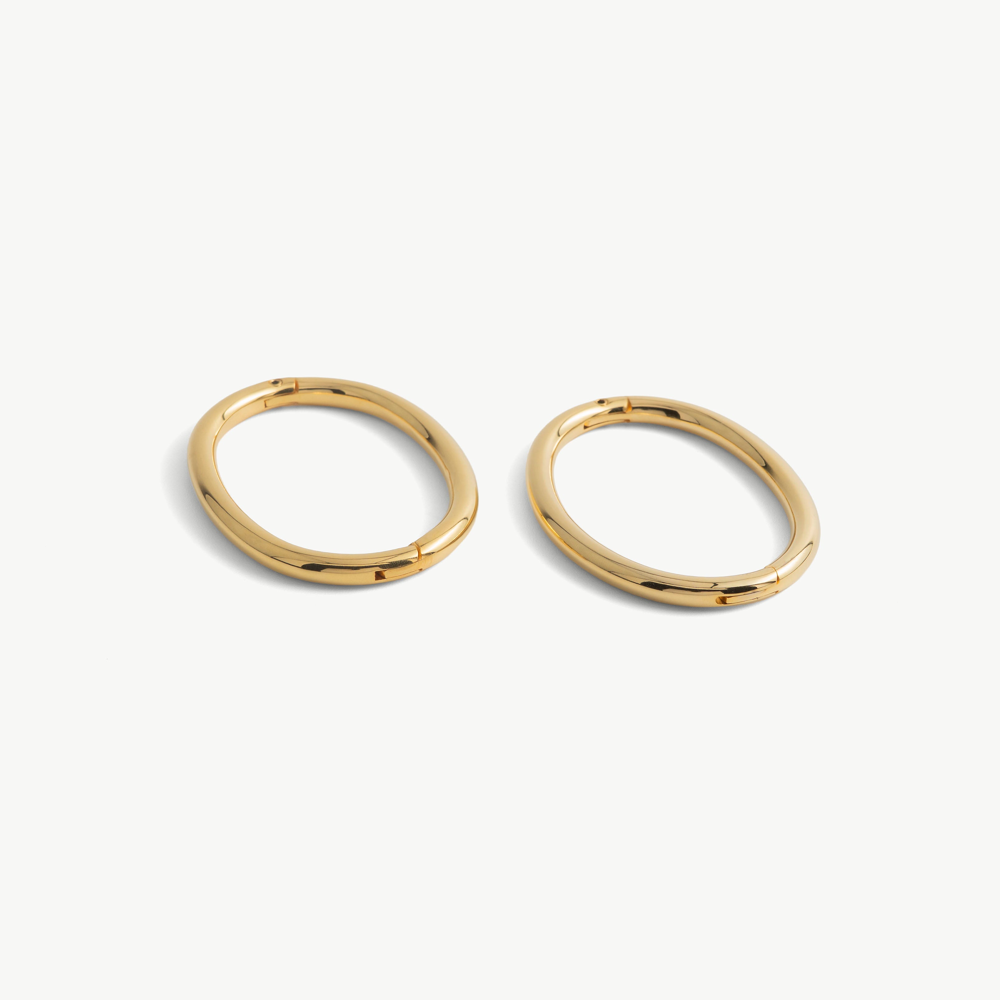 Pair of deSade gold oval wrist bracelets shown together in 6mm steel
