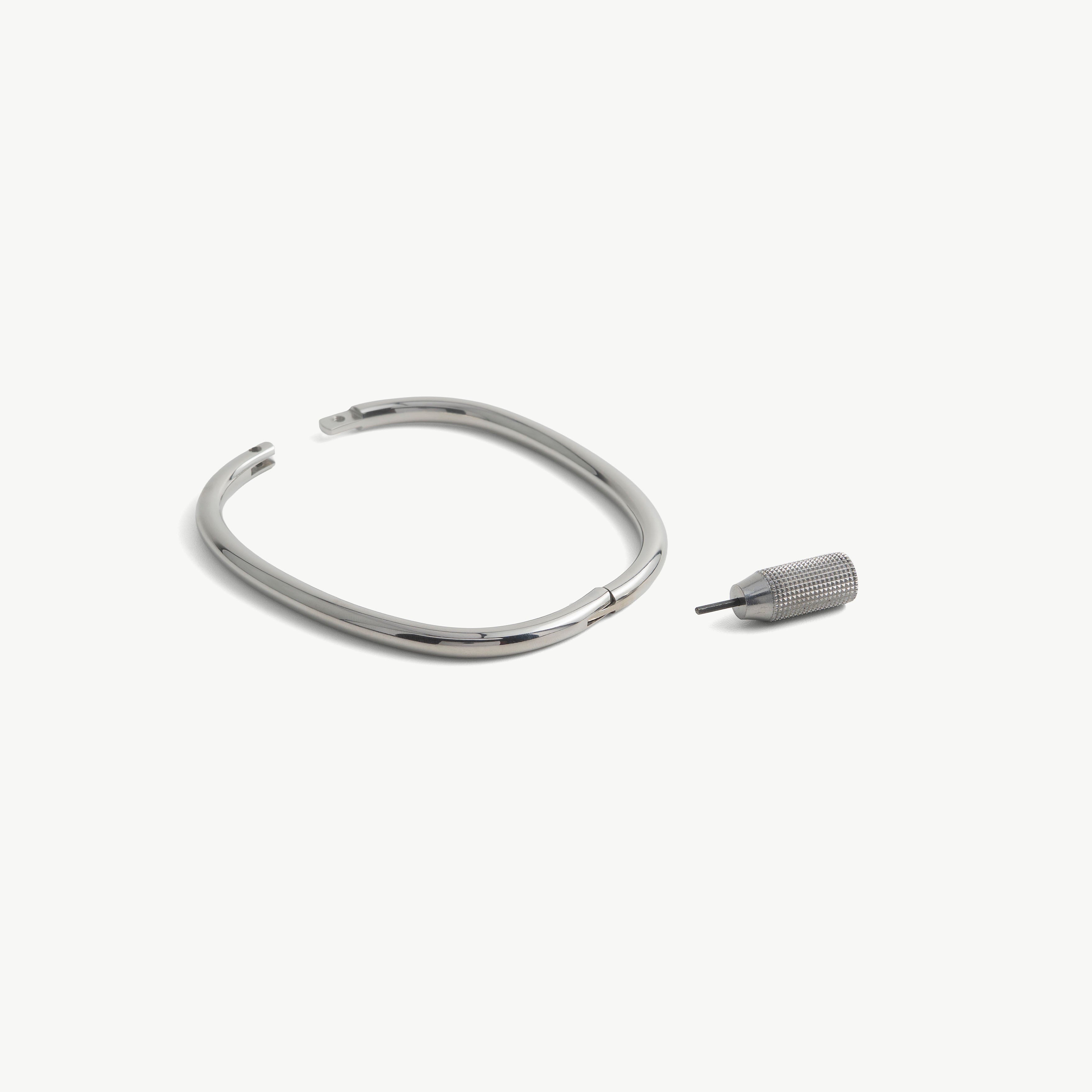 deSade silver ankle bracelet shown open beside its hex key tool