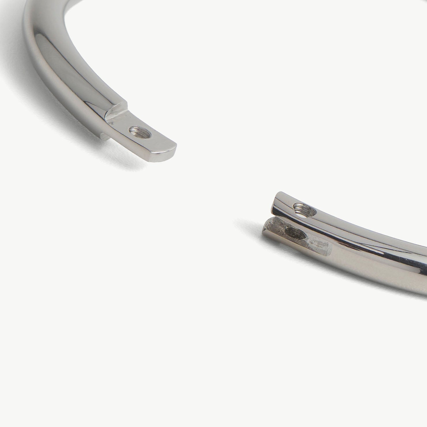 Extreme close-up of the deSade silver bracelet's open ends and hex lock screw hole