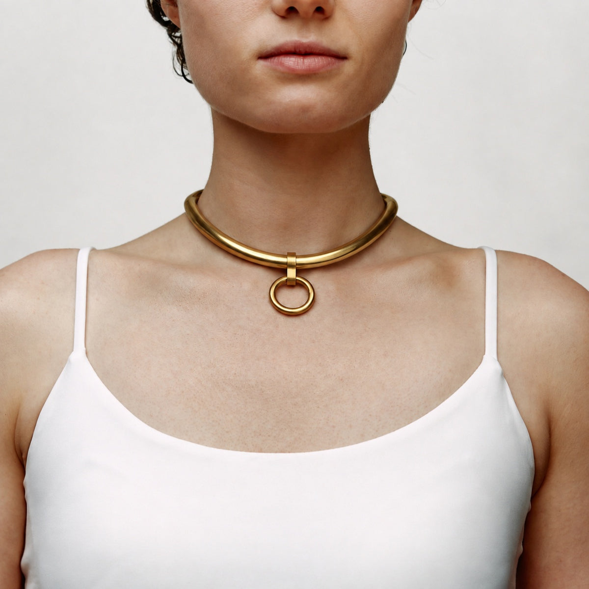deSade gold ergonomic day collar worn on the neck, front view with hanging O-ring