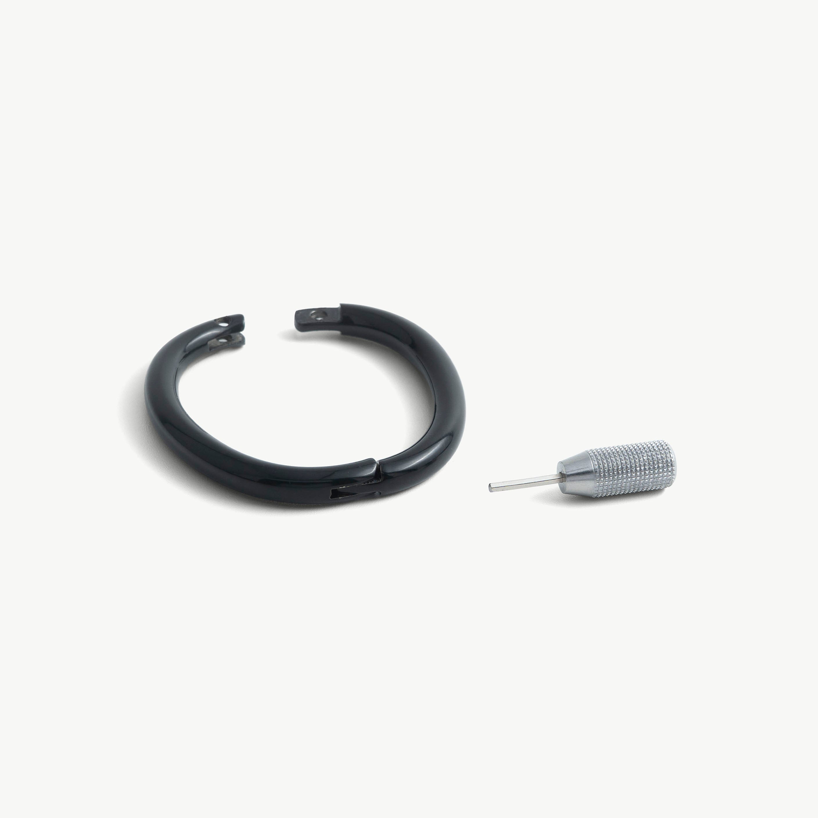 deSade black wrist bracelet shown open beside its hex key tool
