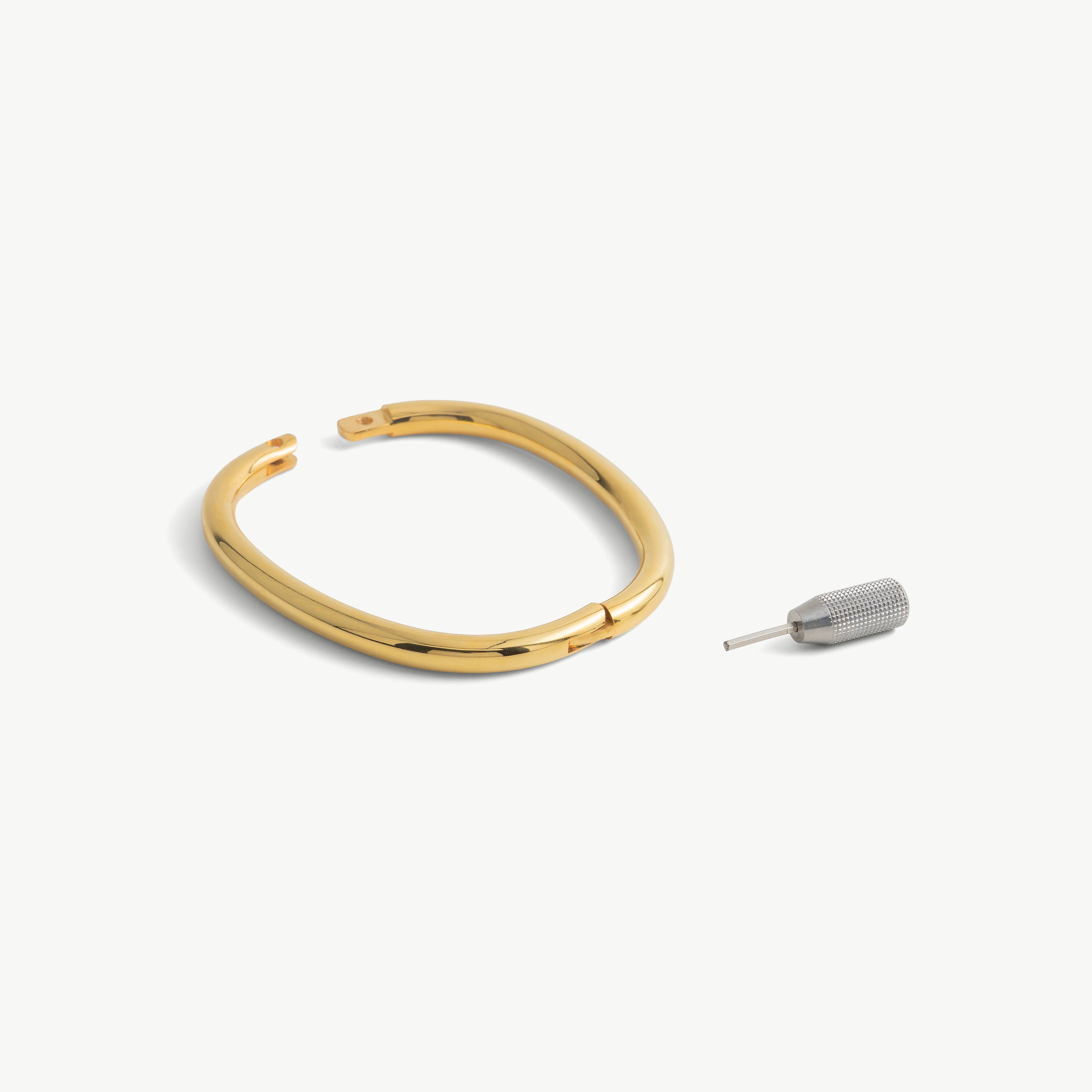 deSade gold ankle bracelet shown open beside its hex key tool