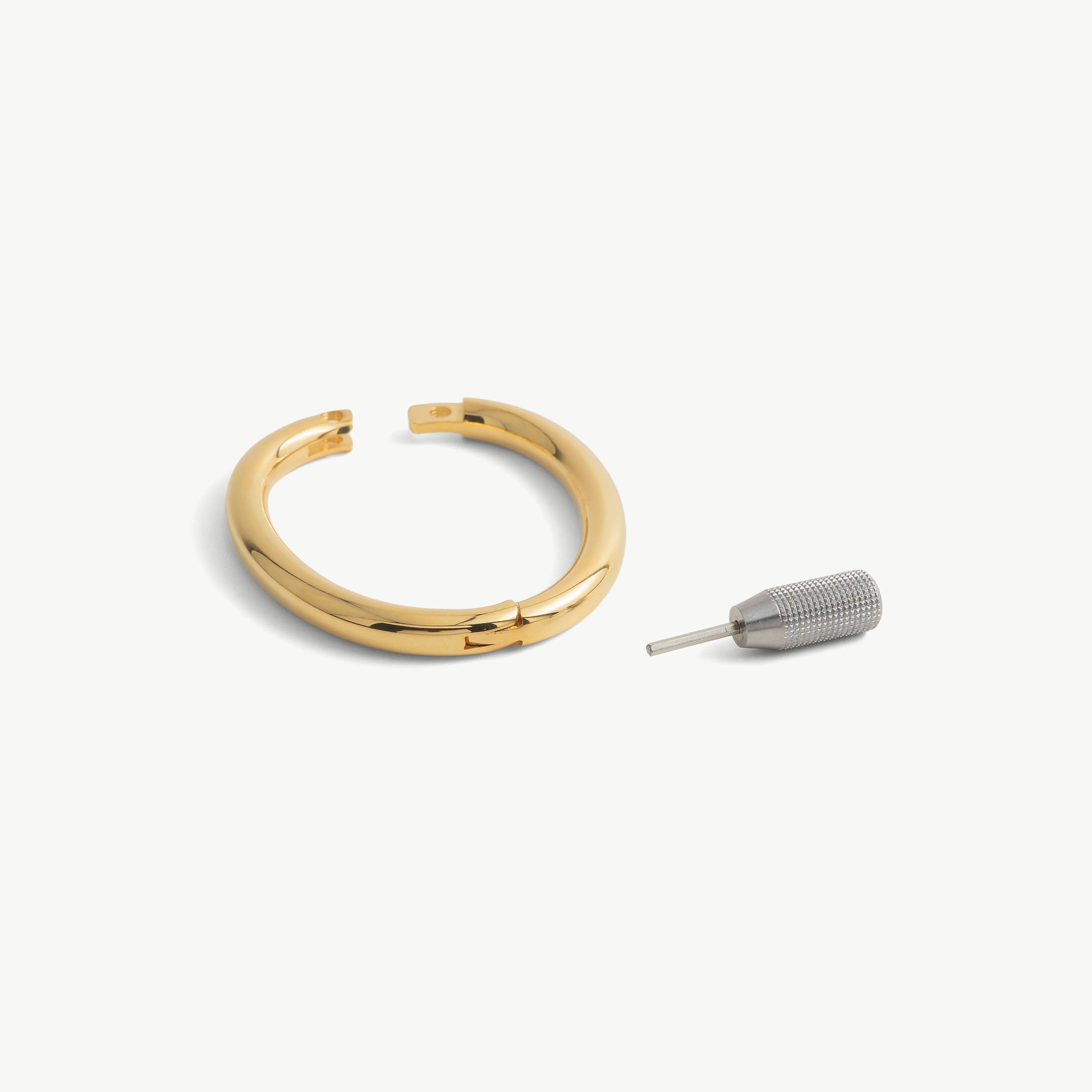 deSade gold wrist bracelet shown open beside its hex key tool