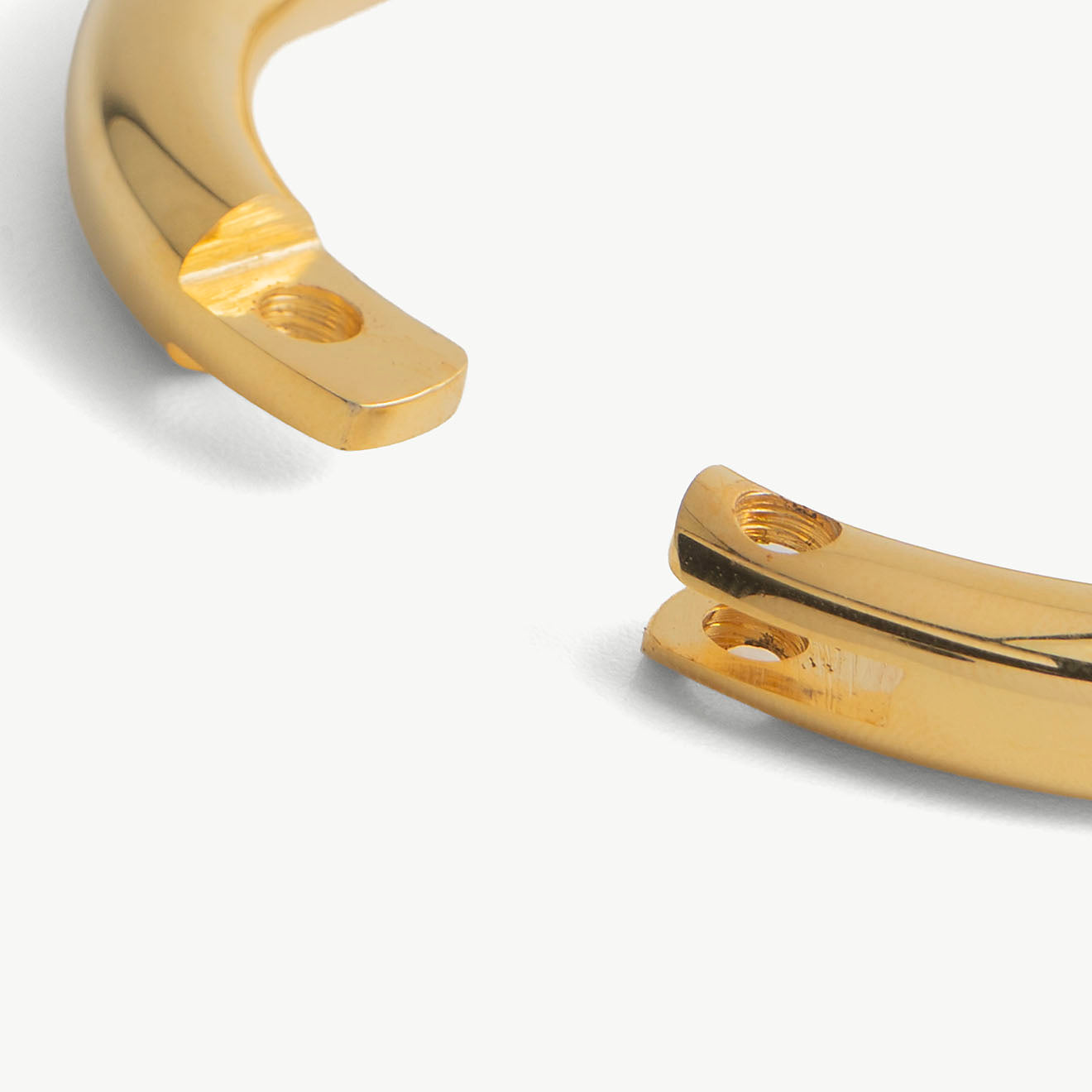 Extreme close-up of the deSade gold wrist bracelet's open ends and lock screw hole