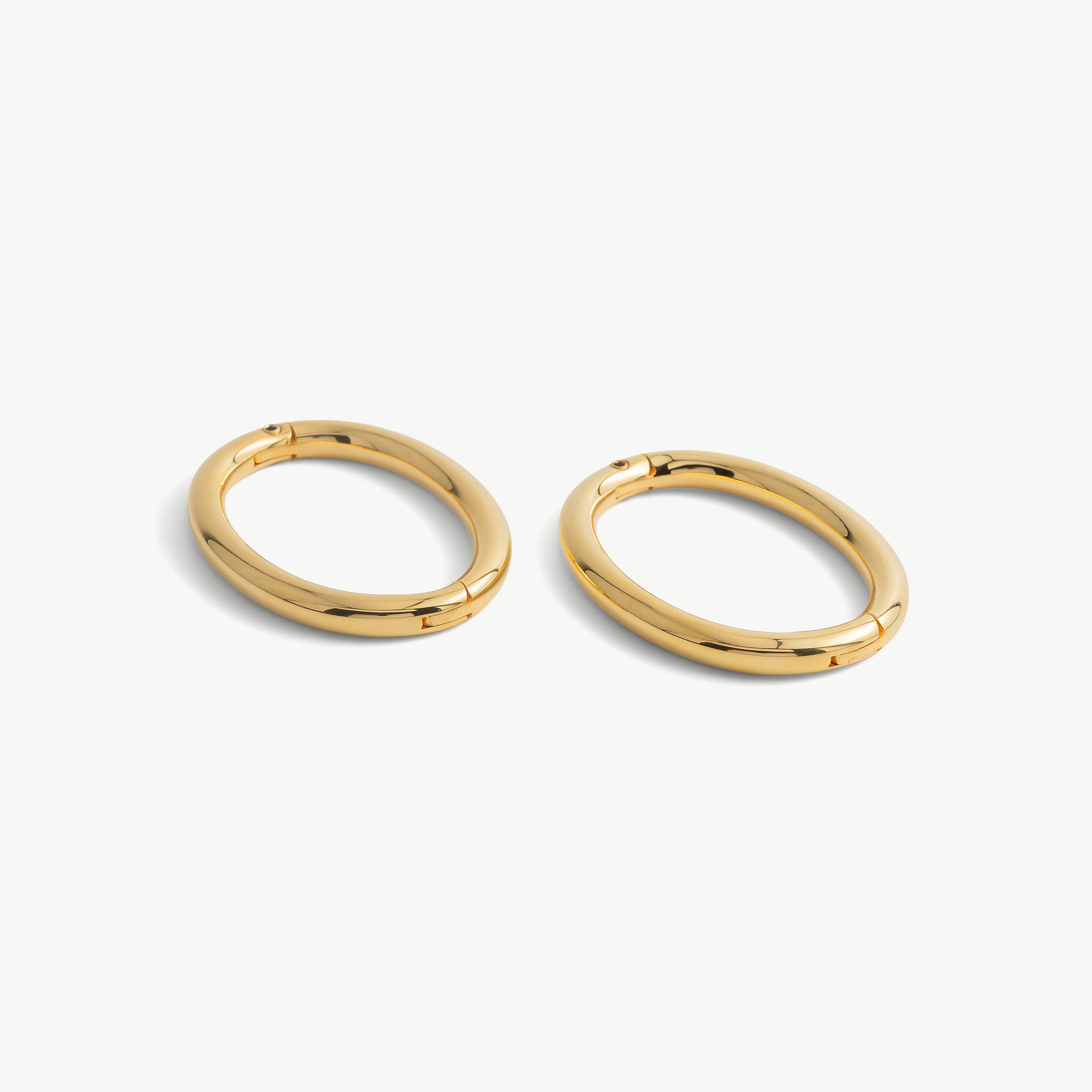 Pair of deSade gold oval wrist bracelets shown together in 8mm steel