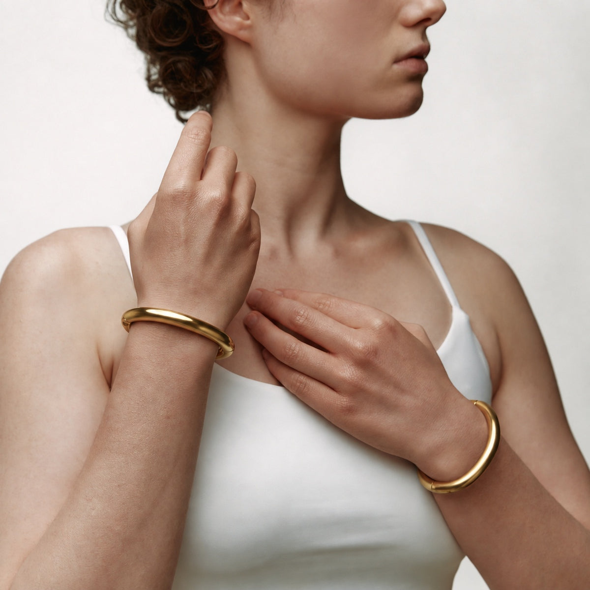 deSade gold wrist bracelets worn on both wrists, hands free