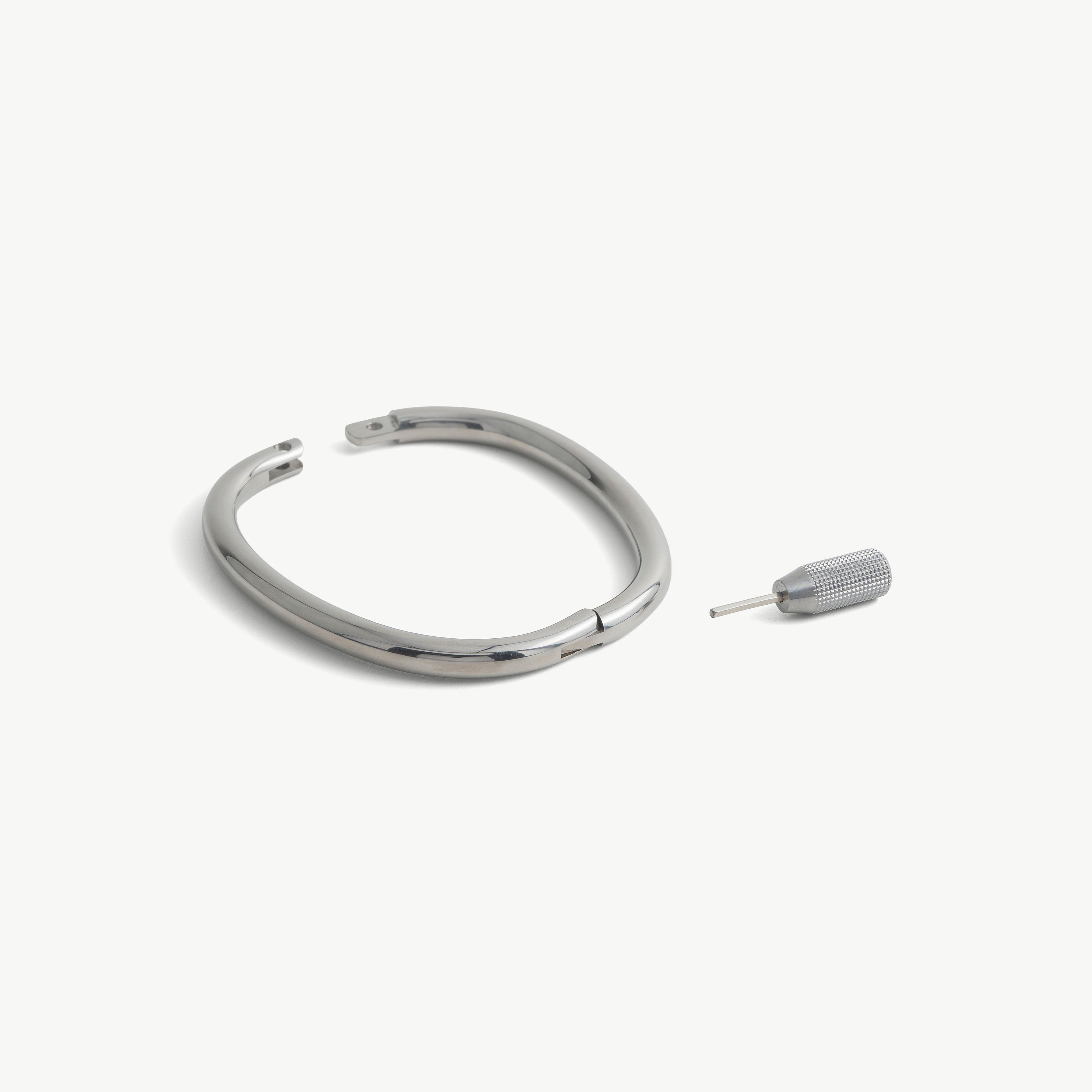 deSade silver ankle bracelet shown open beside its hex key tool