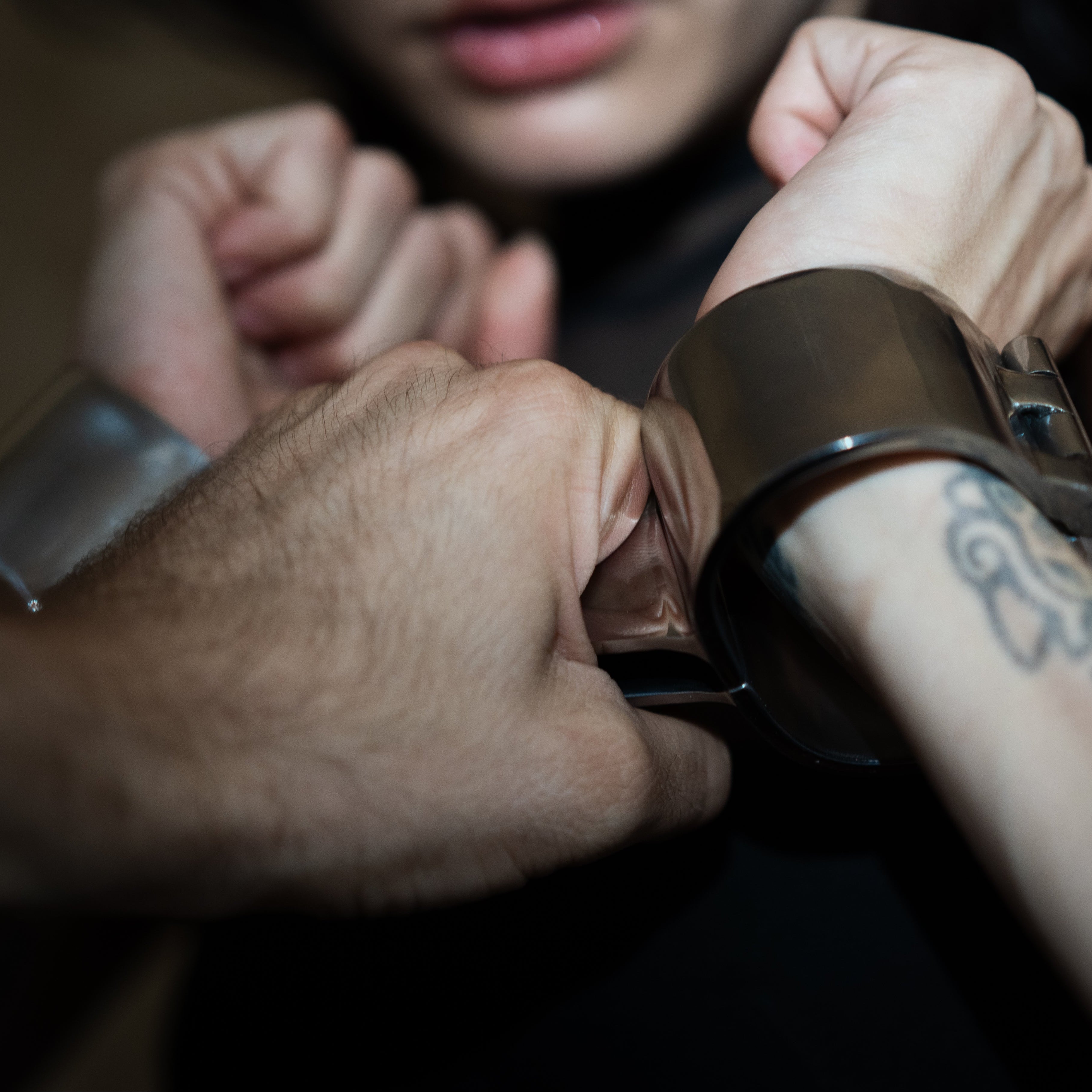 Model wearing wide polished steel angled wrist restraints