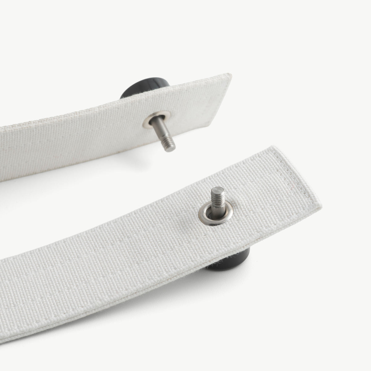 Medical lock pin pushed through the metal eyelet of a white restraint strap and secured with a black lock cap