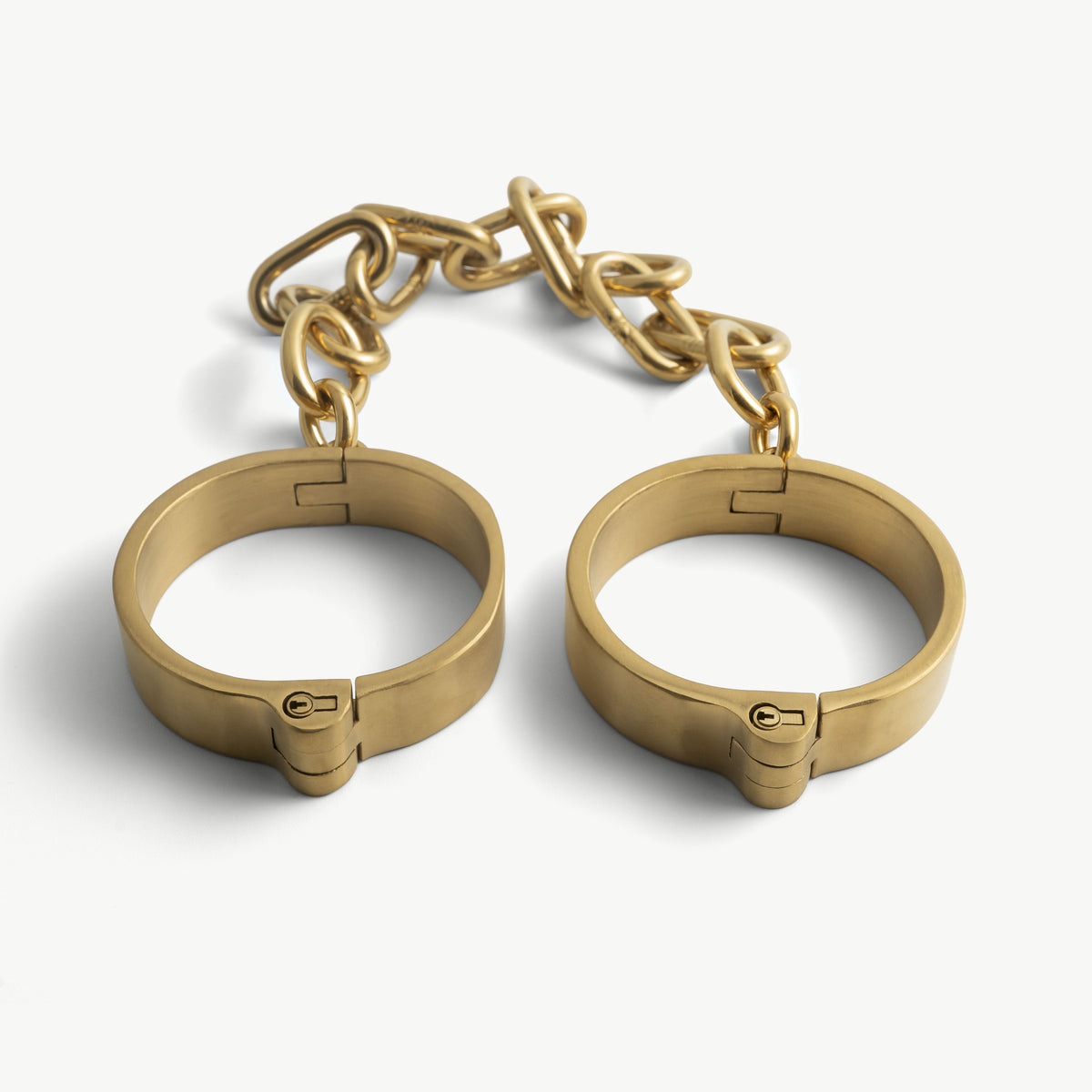 Age of Bondage gold flat legcuffs, two rigid stainless steel bands joined by a fixed polished chain