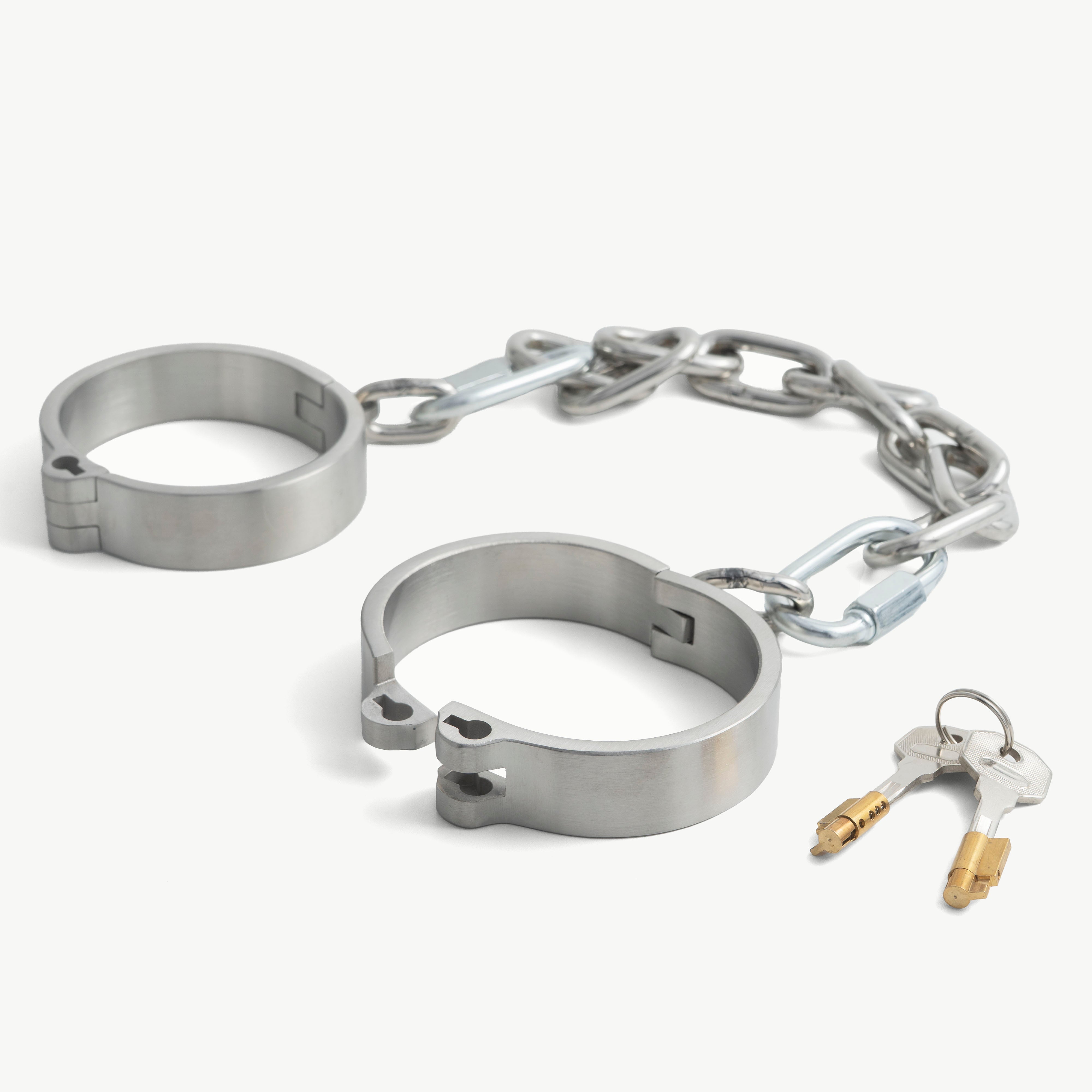 Brushed steel flat legcuffs shown open beside the push-in lock and key