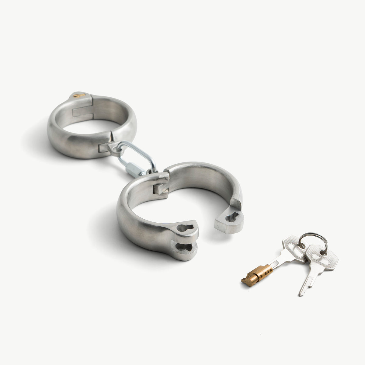 Rounded handcuffs shown open with the push-in lock and keys