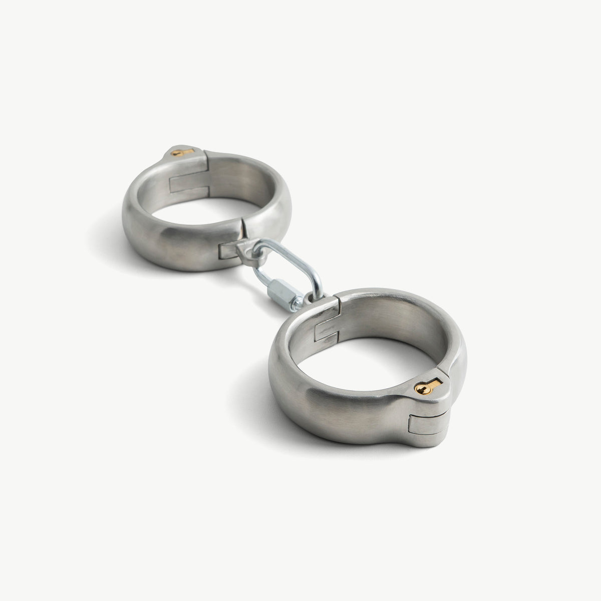 Rounded brushed stainless steel handcuffs with push-in lock and swivel connector, angled view