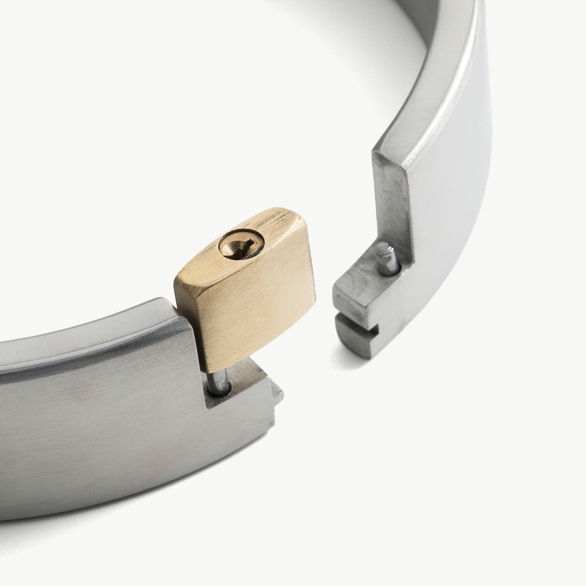 Close-up of the brass padlock securing the brushed steel collar ends