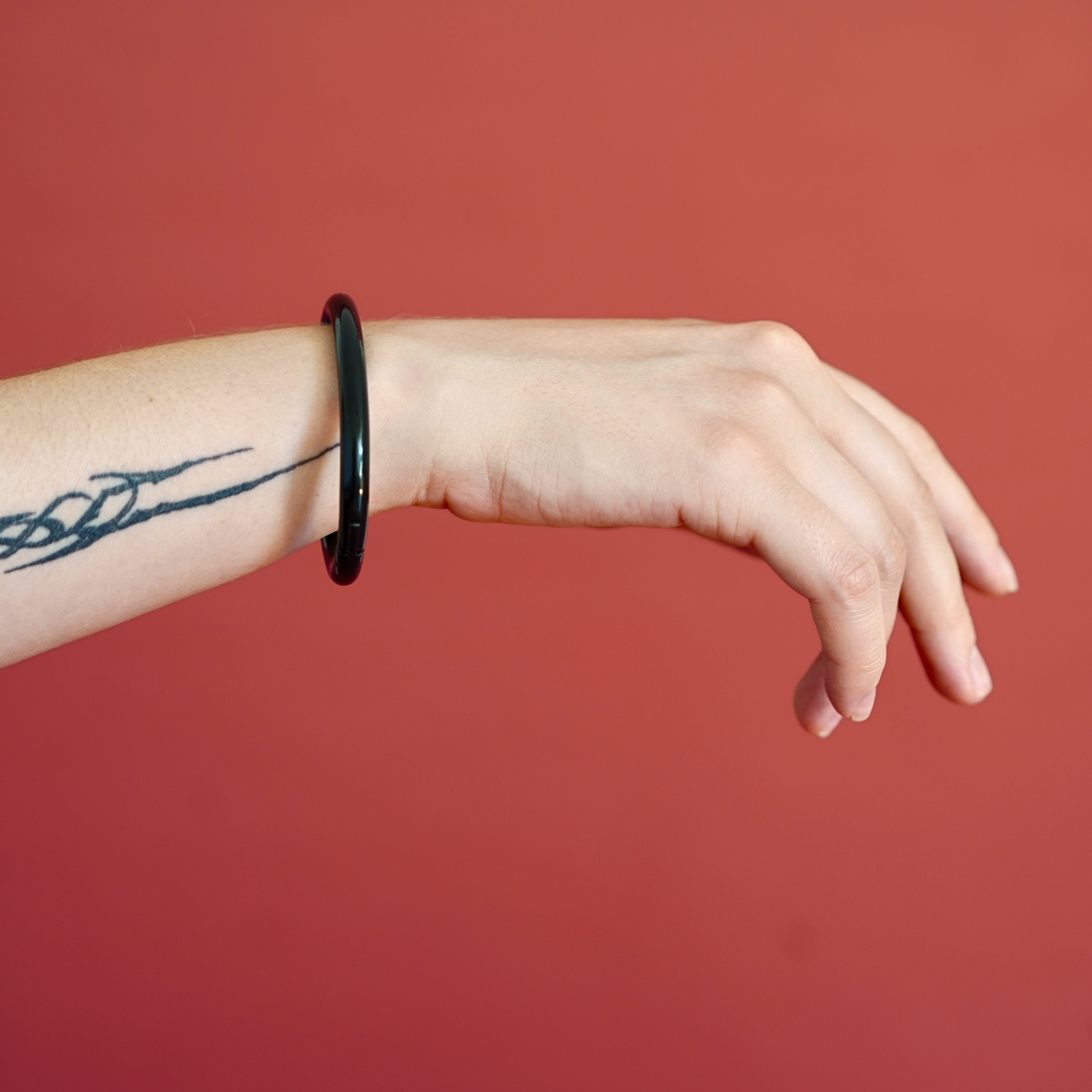 deSade black wrist bracelet worn on a model's wrist