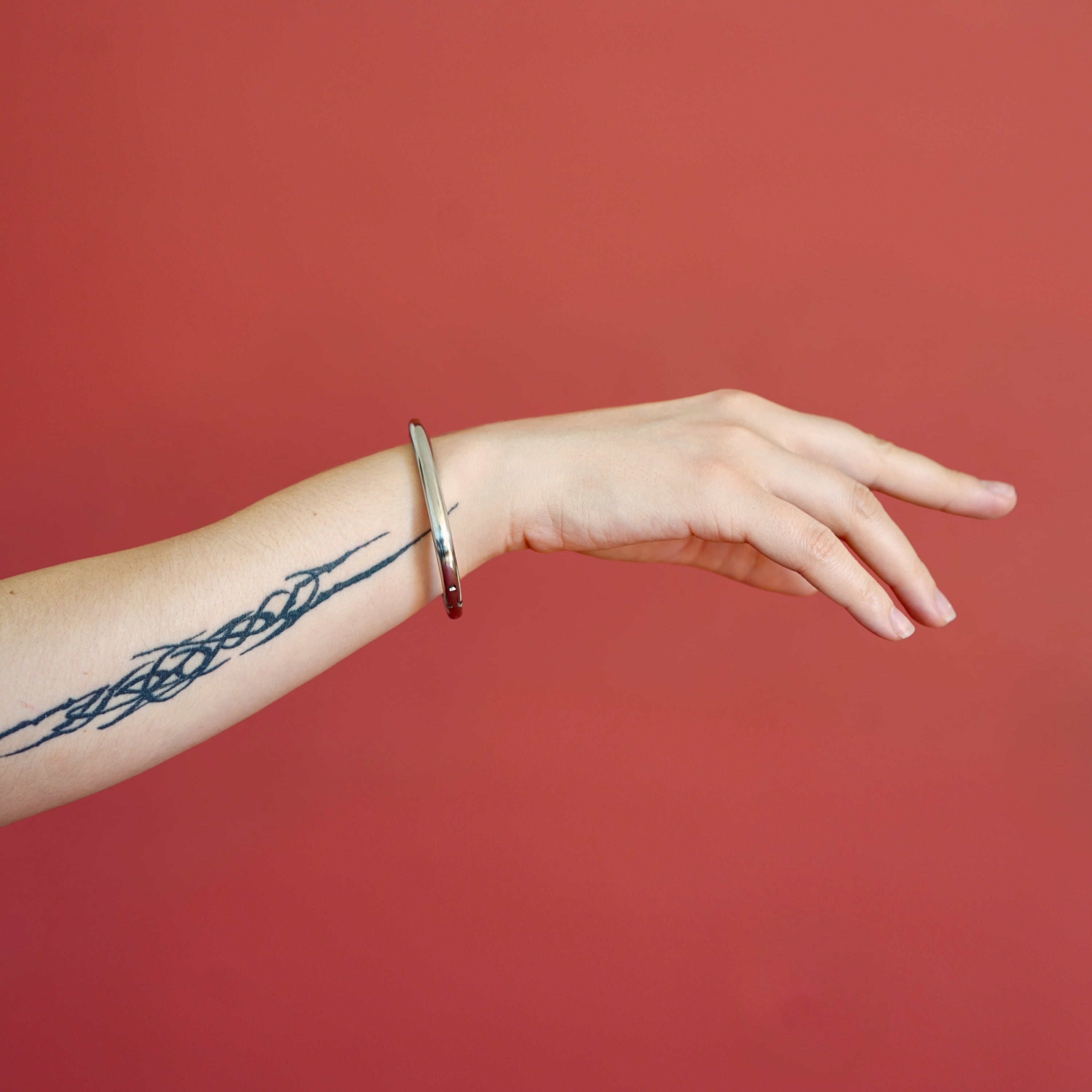 deSade silver wrist bracelet worn on a model's wrist